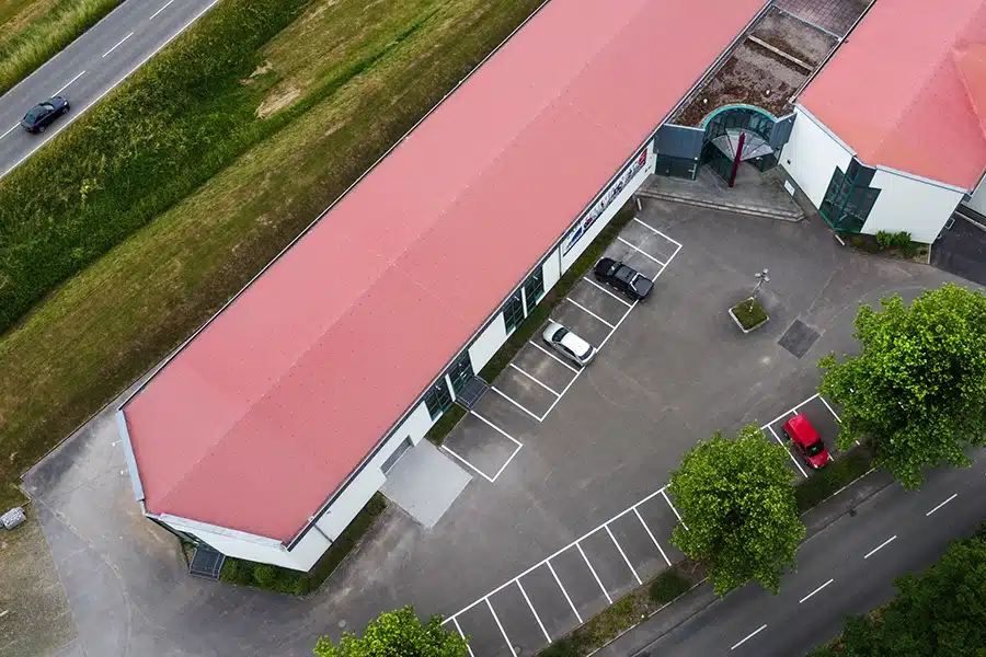 Eine Luftaufnahme eines Gebäudes mit rotem Dach. Dieses Gebäude besteht aus Büroräumen.