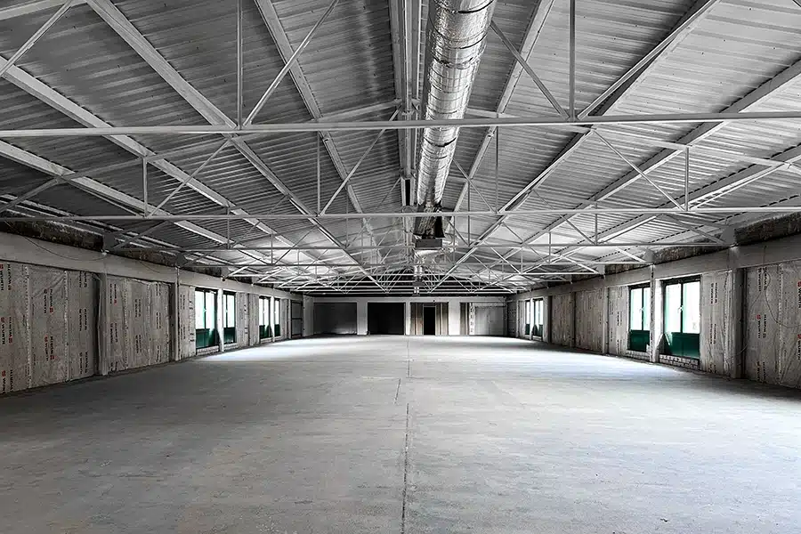 Ein leeres Lagerhaus mit Betonböden, geeignet für Produktionsanlagen oder Lagerräume.